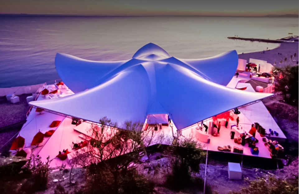 Large illuminated event tent installation beside the water