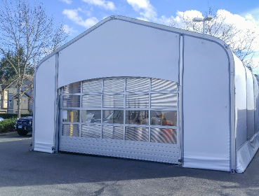 White industrial fabric structure with a large clear-panel entrance