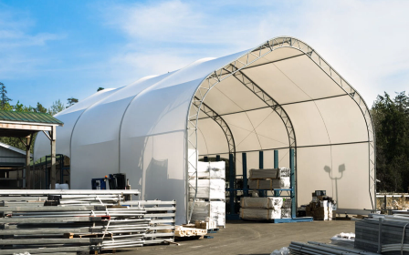 Large white clear-span industrial fabric building used for commercial storage and equipment.