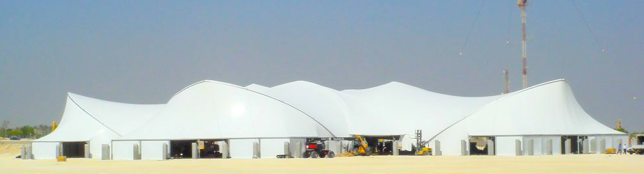 Large white tension fabric structure covering an outdoor event