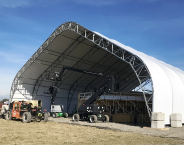 Large clear-span construction shelter protecting equipment and crews