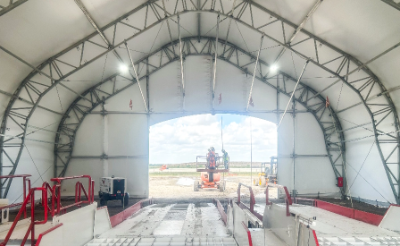 Interior of a large industrial fabric structure with an open equipment access entrance